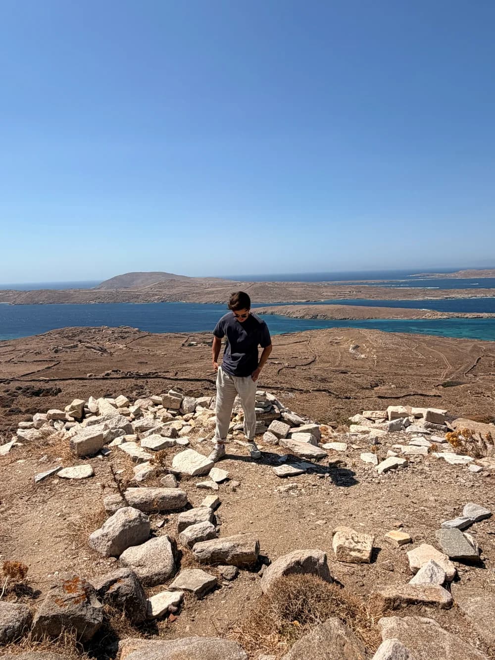 Out on a rocky hillside overlooking blue sea and small islands.