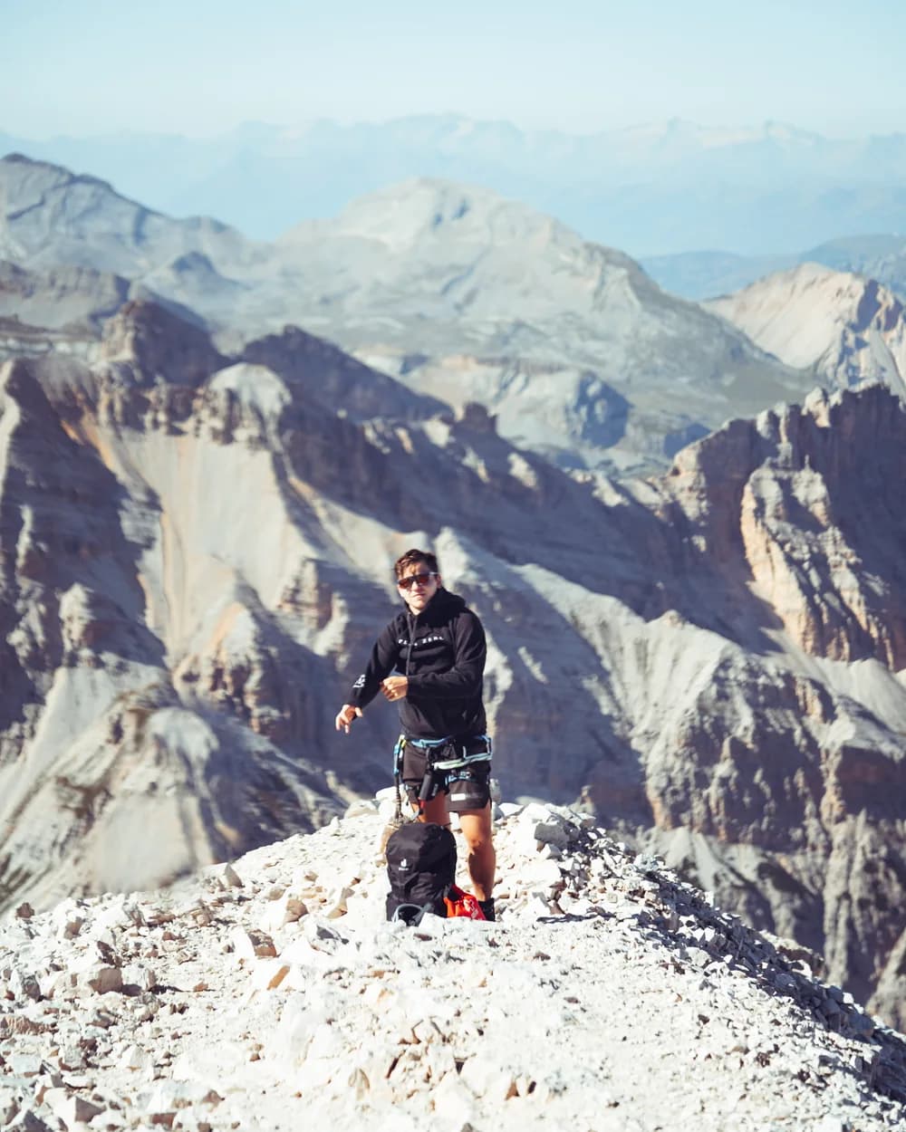 Standing on a rocky summit with a mountain panorama behind me.